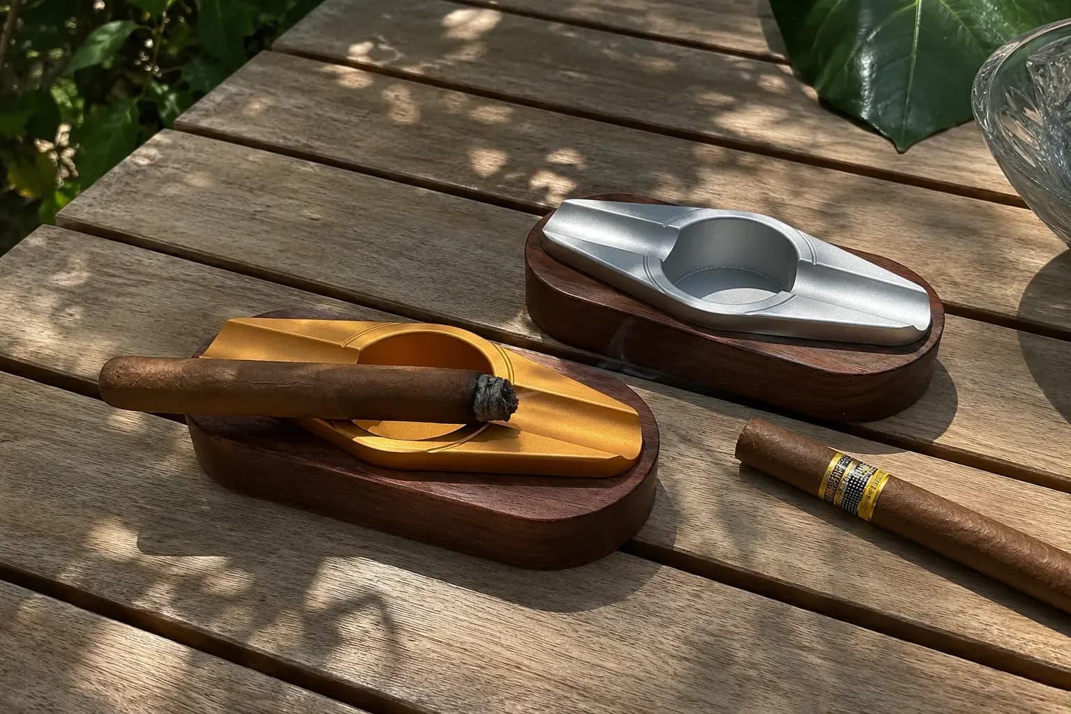 Classic Cigar Ashtray — double-rest lounge pair Elegant gold- and silver-finish aluminium double-rest cigar ashtrays on a slatted wood table
