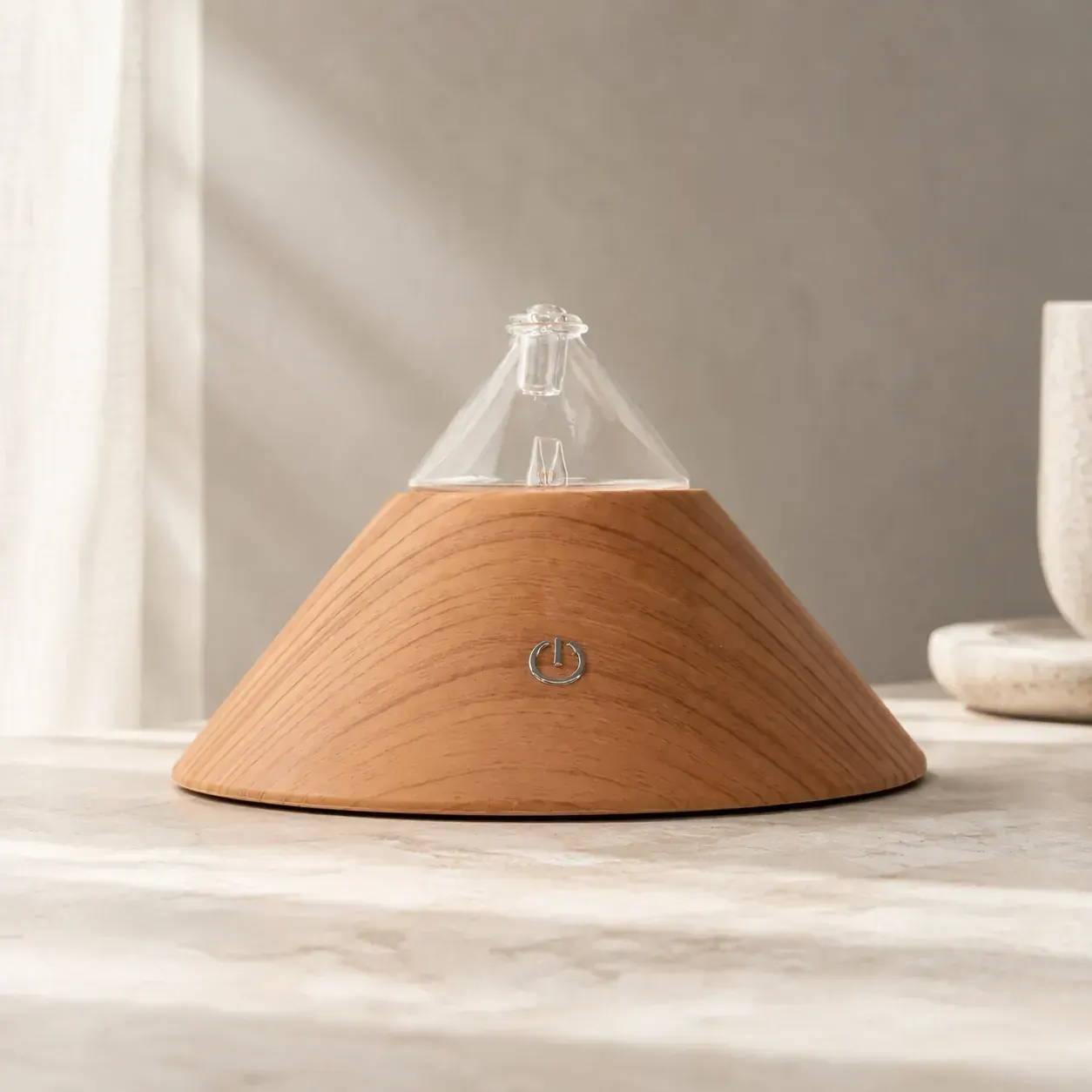 Dual-Fluid Aroma Diffuser — conical wood and glass form Conical wood-and-glass dual-fluid aroma diffuser on a stone surface