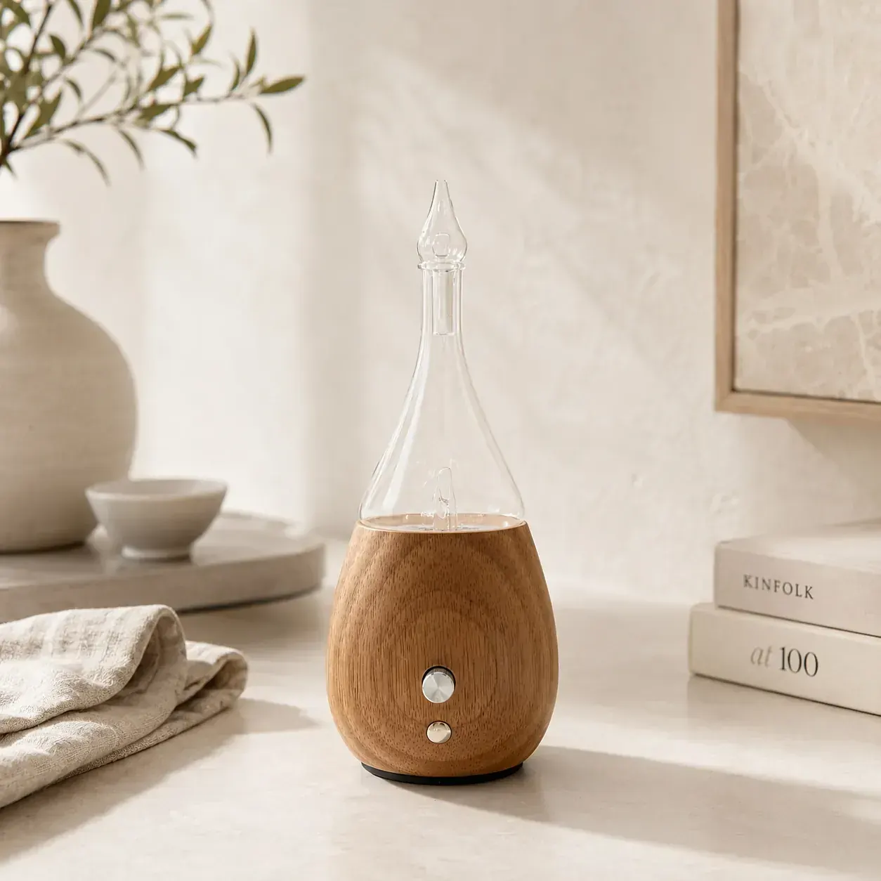 Dual-Fluid Aroma Diffuser — teardrop wood and glass form Teardrop wood-and-glass dual-fluid aroma diffuser in a minimalist lifestyle setting